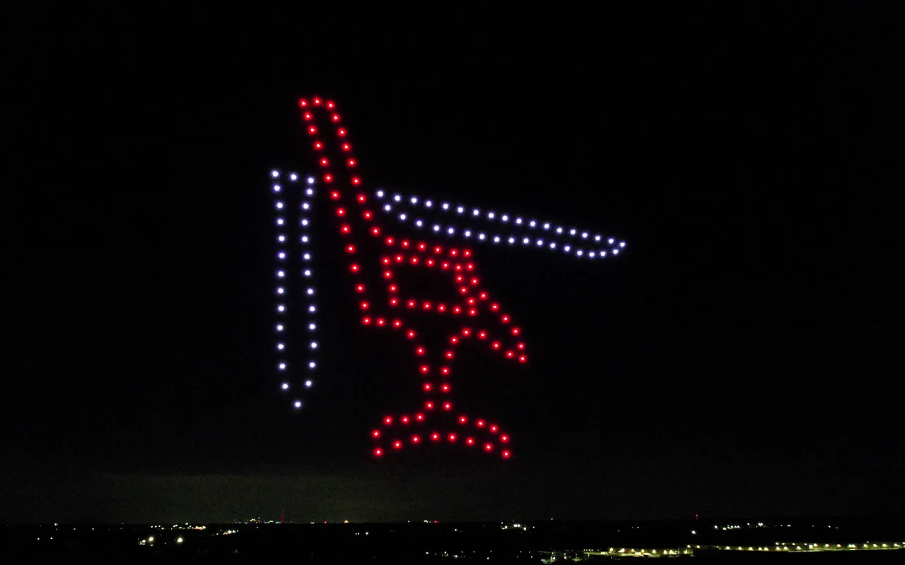 A drone light show forms an aircraft above a valley of town lights at night. Immersion produces drone light shows in Beaver Creek, Colorado.