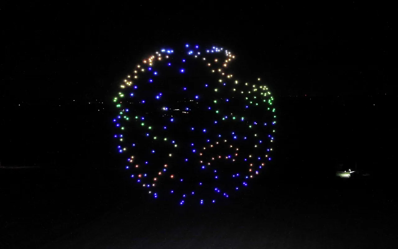 A drone light show forms a globe outlined in white with green continents. Immersion produces drone light shows in Charlotte, North Carolina.
