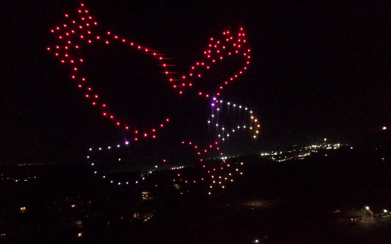 A drone light show forms an eagle above a valley of town lights at night. Immersion produces drone light shows in Grand Junction, Colorado.