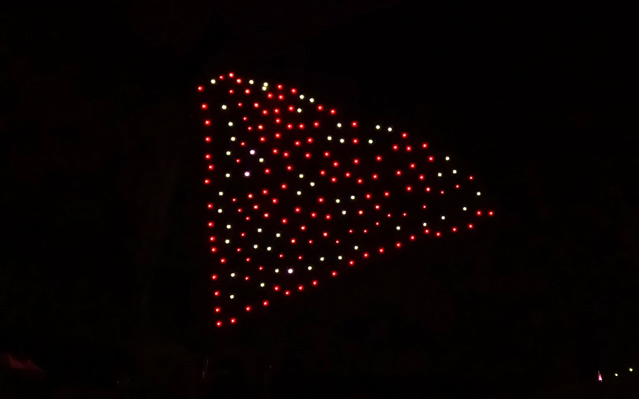 A drone light show forms a lit peak in red and white against the night sky. Immersion produces drone light shows in Keystone, Colorado.