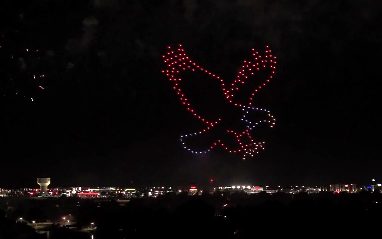 A drone light show forms an eagle with wings spread wide in red and white. Immersion produces drone light shows in Raleigh, North Carolina.