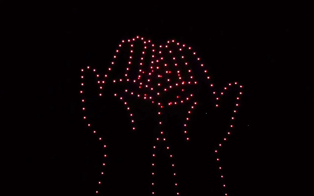 A drone light show forms a pair of open hands against the night sky. Immersion produces drone light shows in Telluride, Colorado.