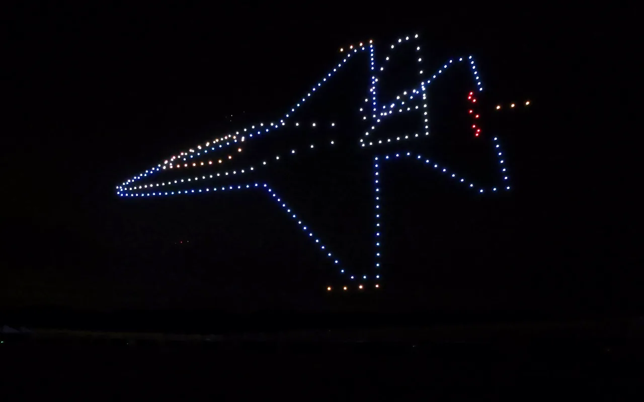 A drone light show forms a space shuttle outlined in blue and white against the night sky. Immersion produces drone light shows in Tucson, Arizona.