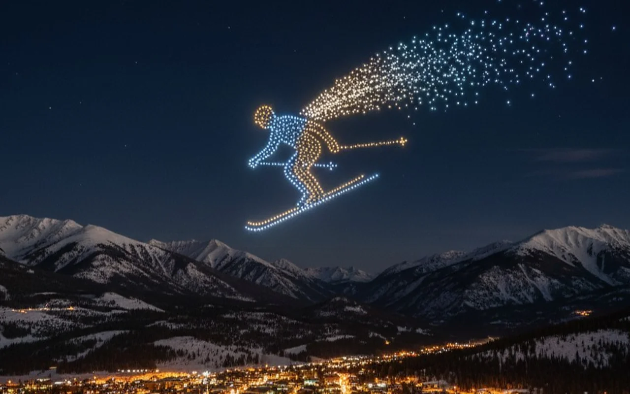 A drone light show glowing above a Colorado mountain resort at night, the fleet lit over the high country.