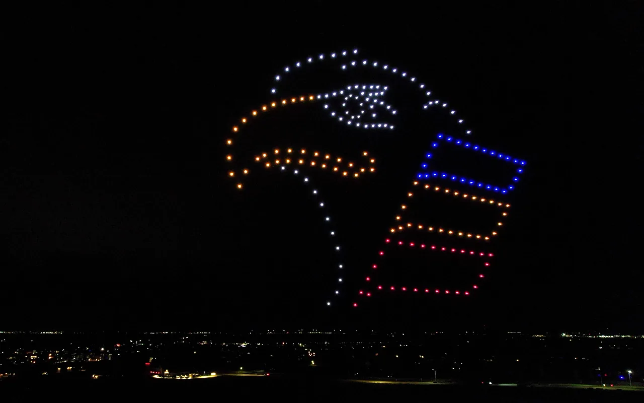 A Colorado Eagles drone light show forms an eagle and a team jersey above the crowd at night. Immersion produces drone light shows in Windsor, Colorado.
